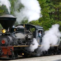 a steam engine on a train track with smoke coming out of it