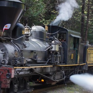 a steam train on a track with smoke coming out of it