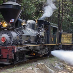 a steam engine is sitting on a train track