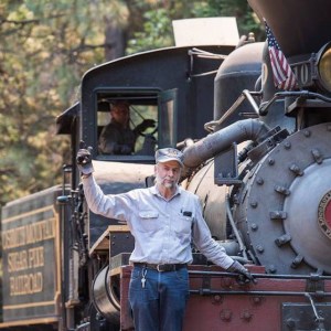 a man standing next to a train