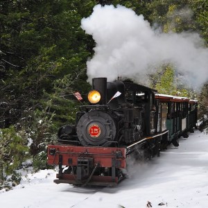 a steam train on a track with smoke coming out of it