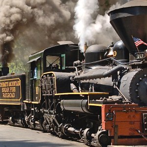 a steam engine on a train track with smoke coming out of it