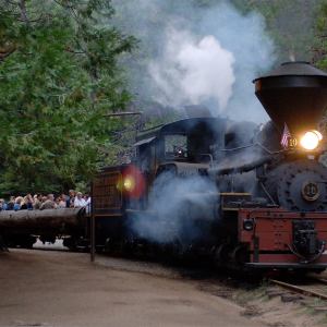 a steam engine is on a train track with smoke coming out of it