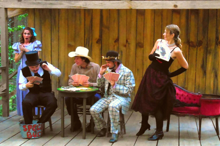 a group of people standing on top of a wooden table