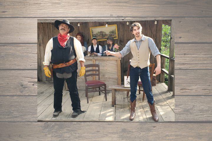 Western scene with two men in cowboy attire, one in black hat and one in beige vest, wooden backdrop.