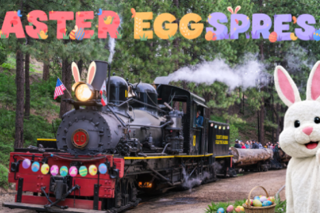 Steam train with bunny ears, Easter decorations, and mascot in forest, labeled 'Easter Eggspress'.